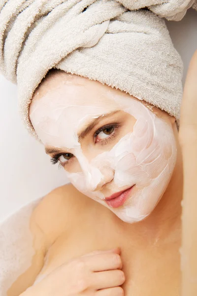 Mujer relajante en bañera con mascarilla facial . — Foto de Stock