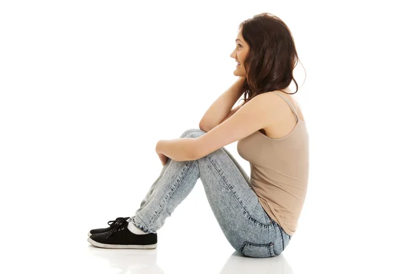 Joven mujer sonriente sentada en el suelo . —  Fotos de Stock