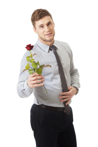 Un bel homme tenant une rose rouge . — Photo