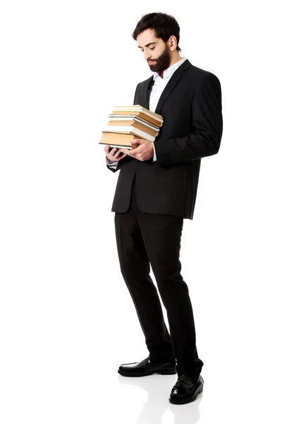 Mladý podnikatel drží Stoh knih. — Stock fotografie