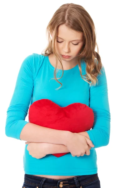 Young woman with heart shaped pillow — Stock Photo, Image