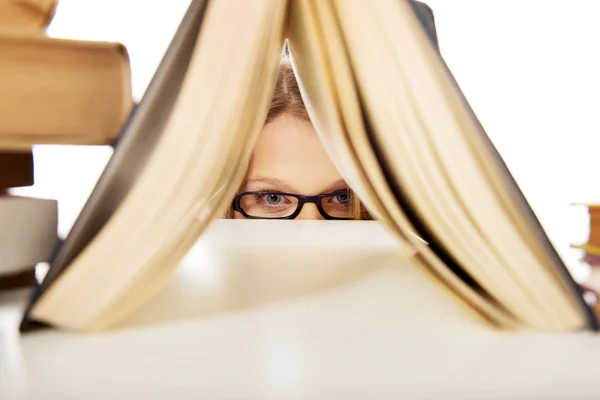 Jonge vrouw verstopt achter een boek — Stockfoto