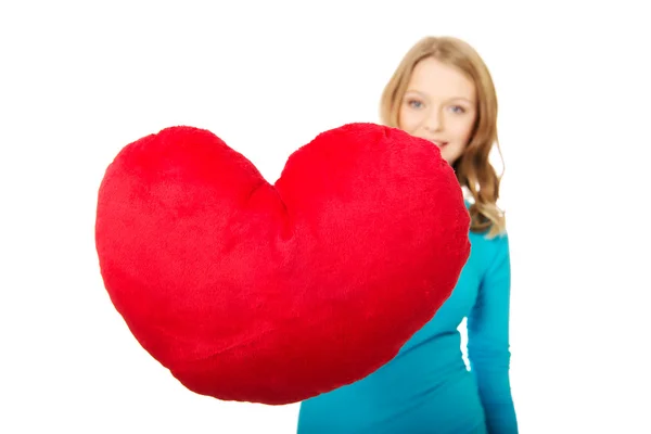 Young woman with heart shaped pillow — Stock Photo, Image