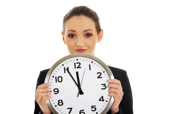 Businesswoman holding a big clock. Stock Image