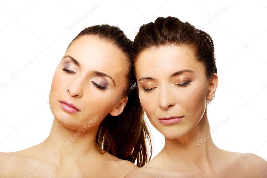 Two sisters with make up and eyes closed.