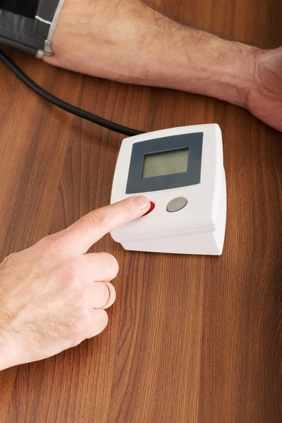 Man checking his blood pressure at home — Stock Photo, Image