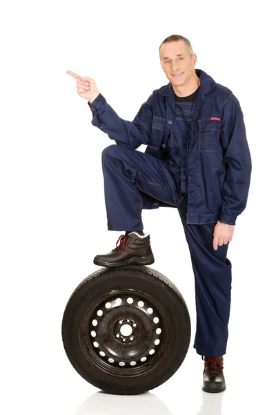Mechanik s nohou na pneumatiky, vlevo — Stock fotografie