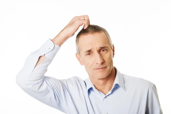 Confused man scratching his head — Stock Photo, Image