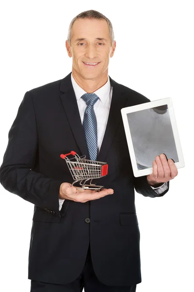 Zakenman holding winkelwagentje en Tablet PC — Stockfoto