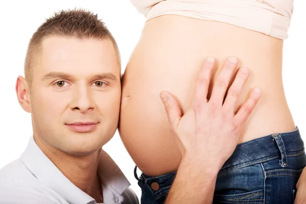 Otec poslouchá maminky těhotné bříško — Stock fotografie