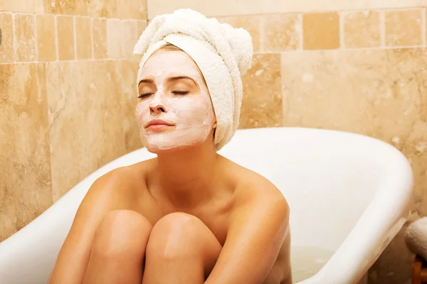 Mujer sentada en baño con mascarilla —  Fotos de Stock
