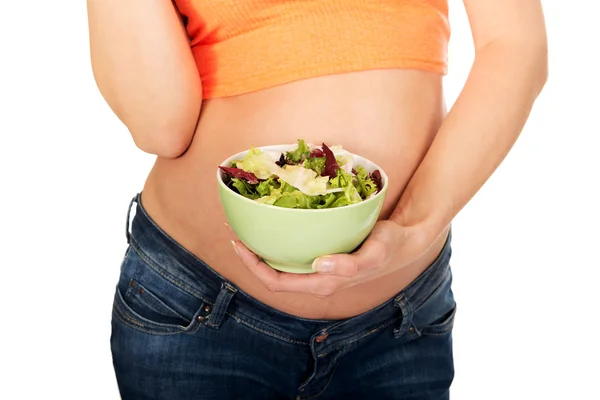 Pregnant woman holding a bowl with salad — Stock Photo, Image