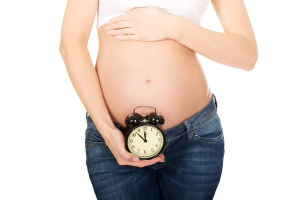 Pregnant woman with an alarm clock Stock Image