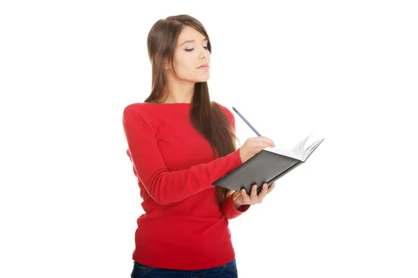 Estudante feminina escrevendo em caderno . — Fotografia de Stock