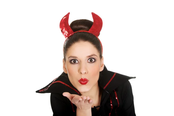 Vrouw in duivel kostuum blaast een kus. — Stockfoto
