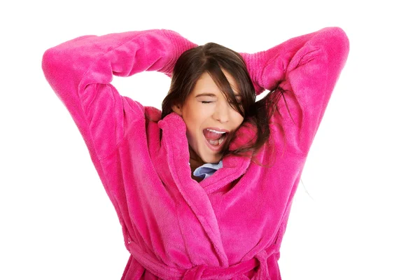 Yawning woman in pink bathrobe. — Stock Photo, Image