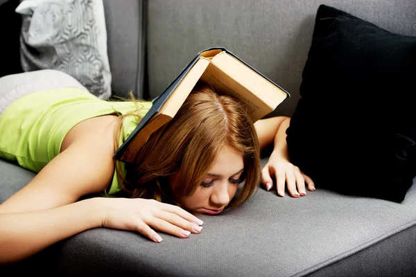 Tired woman with book on head. — Stock Photo, Image