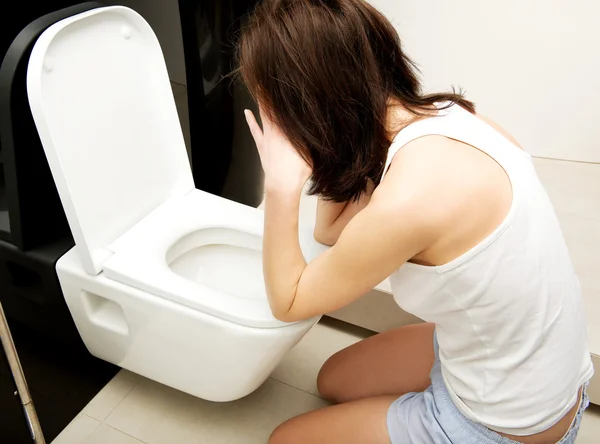 Mulher vomitando no banheiro . — Fotografia de Stock