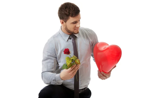 Homem ajoelhado com rosa e balão . — Fotografia de Stock