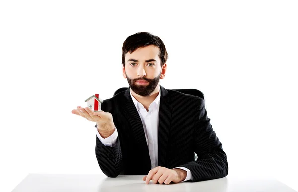 Businessman with a house model in hand. — Stock Photo, Image