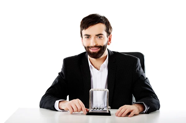 Mann bewegt Newtonbälle im Büro. — Stockfoto