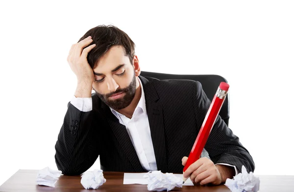 Tired businessman writing in the office — Stock Photo, Image