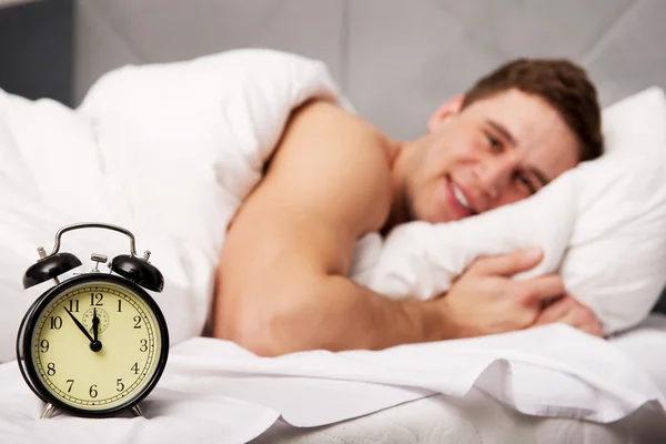 Homem com despertador no quarto. — Fotografia de Stock