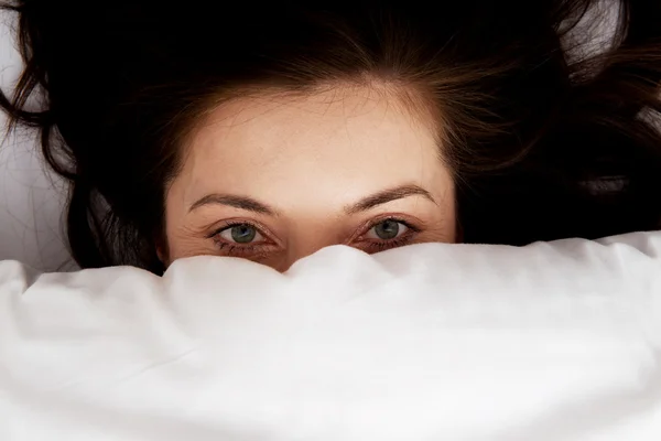 Mulher assustada na cama. — Fotografia de Stock