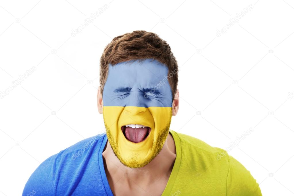 Screaming man with Ukraine flag on face.