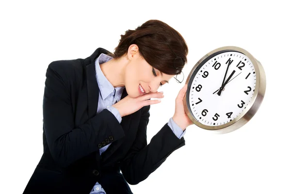 Müde Geschäftsfrau hält Uhr in Händen. — Stockfoto