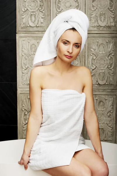 Vacker kvinna sitter på badkar. — Stockfoto