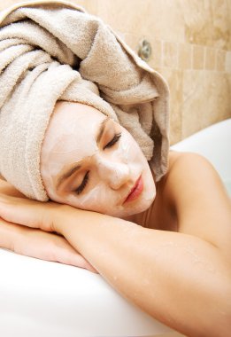Yüz maskesi ile banyoda rahatlatıcı kadın.