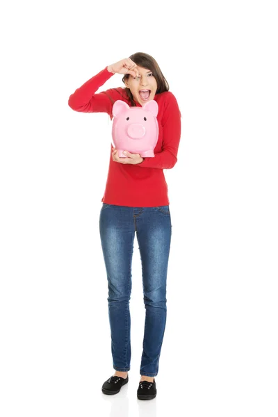 Mujer feliz poniendo una moneda en Piggybank . —  Fotos de Stock