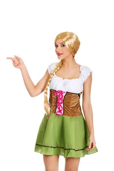 Woman in Bavarian dress pointing aside. — Stock Photo, Image