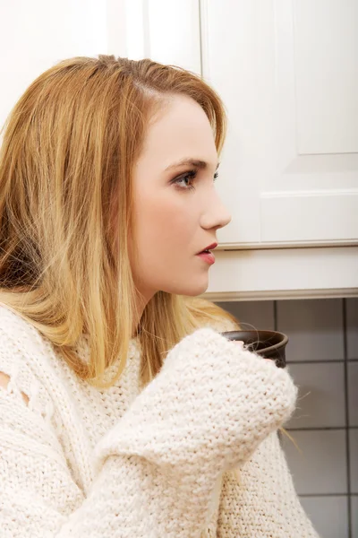 Mooie vrouw drinken koffie in de keuken. — Stockfoto