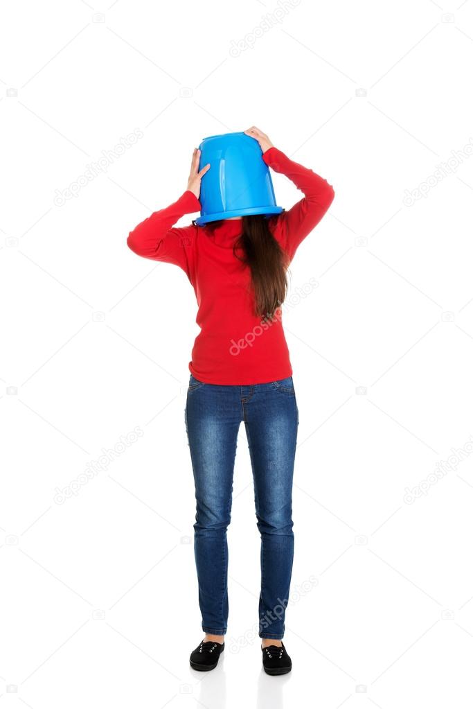 Woman with plastic bucket on head.