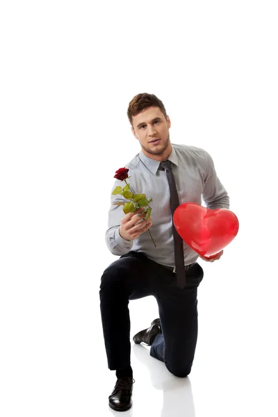 Man kneeling with red rose — Stock Photo, Image