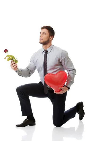 Man kneeling with red rose — Stock Photo, Image