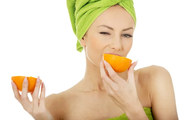 Mooie vrouw eten oranje. — Stockfoto