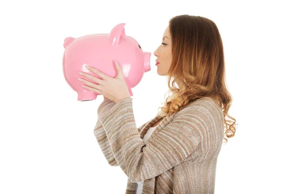 Casual woman kissing piggy-bank. — Stock Photo, Image