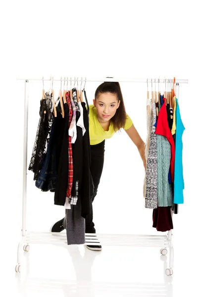 Junge Frau mit Kleidern auf Kleiderbügel. — Stockfoto