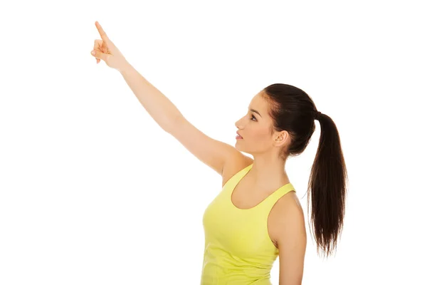 Frau in Sportkleidung zeigt nach oben. — Stockfoto