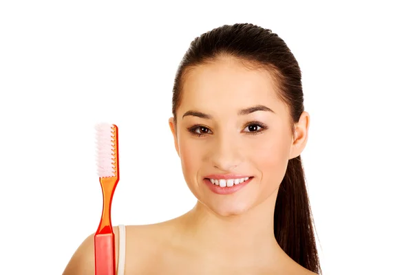 Mujer conmocionada sosteniendo un gran cepillo de dientes . — Foto de Stock