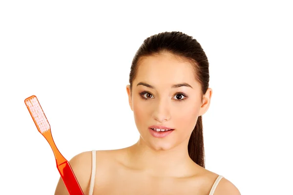 Schockierte Frau mit großer Zahnbürste. — Stockfoto