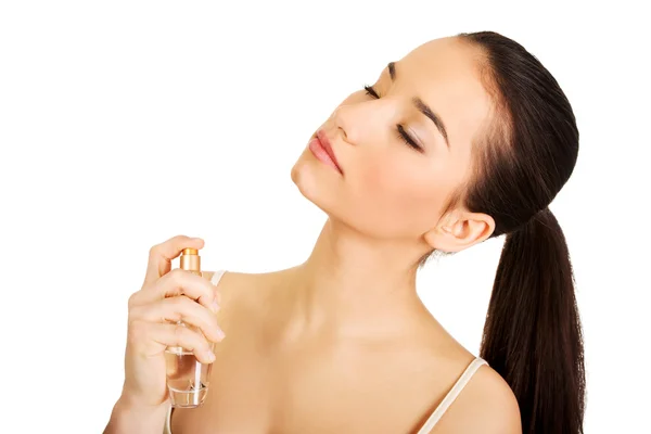 Jovem mulher aplicando parfume . — Fotografia de Stock