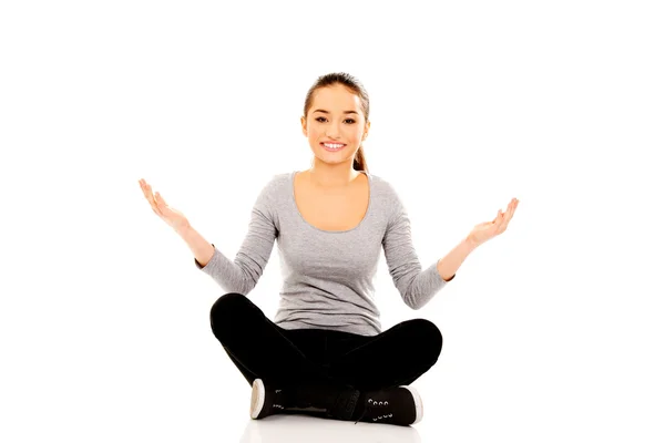 Woman sitting cross legged with open hands. — Stock Photo, Image