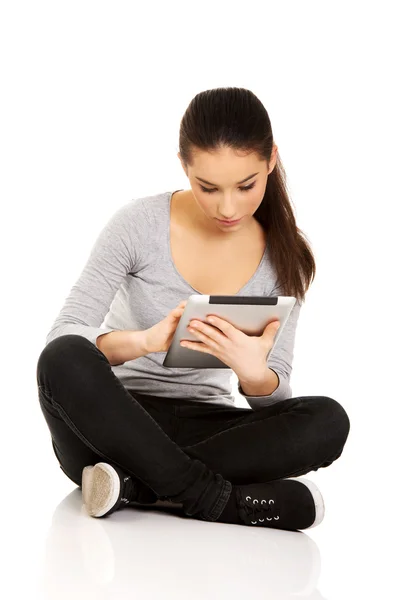 Mulher com tablet sentado de pernas cruzadas . — Fotografia de Stock