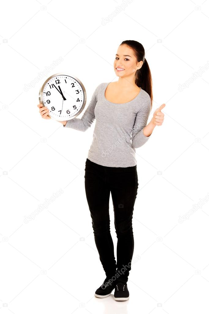 Woman with a clock and thumb up.
