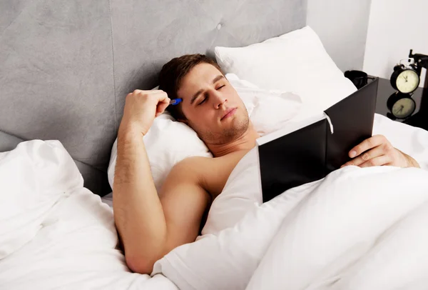 Doordachte man met een notitie in zijn bed. — Stockfoto