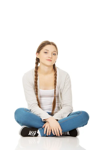 Happy teen woman sitting cross legged. — Stock Photo, Image